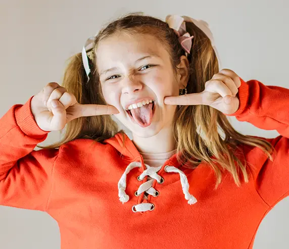 Menina fazendo careta divertida e mostrando o sorriso